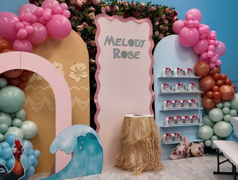 Close-up of the “Melody Rose is 3” birthday party setup featuring the main Moana-themed focal point with colorful tropical decor and custom signage.