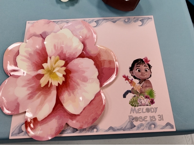 Close-up of Moana-themed table setting for Melody Rose’s 3rd birthday party with personalized name cards and tropical decor.