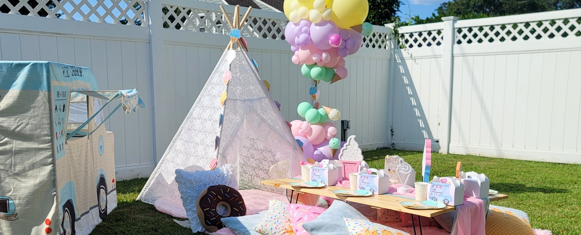 Ice Cream themed magical picnic table party setup by Kidz Kastle in Cranston, RI, featuring colorful decorations, balloons, and party supplies for a children’s birthday celebration.